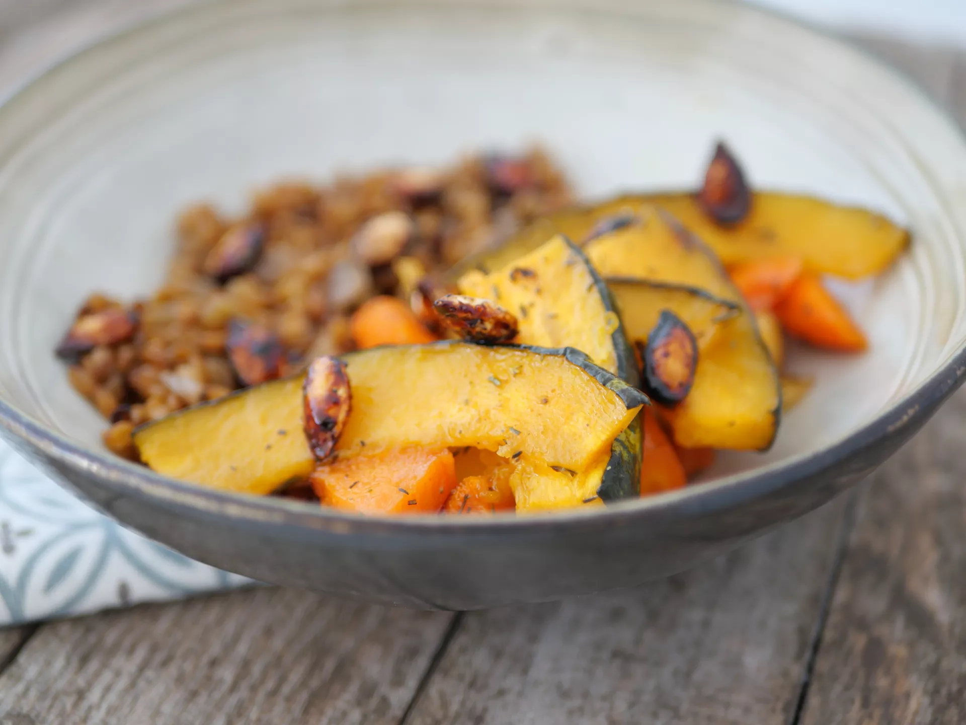 Plat végétarien préparé par Ansamble, composé de tranches de courge rôtie et d'un accompagnement de céréales, illustrant l'engagement de la société envers une cuisine saine et équilibrée.