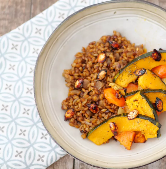 Plat végétarien préparé par Ansamble, composé de tranches de courge rôtie et d'un accompagnement de céréales, illustrant l'engagement de la société envers une cuisine saine et équilibrée.